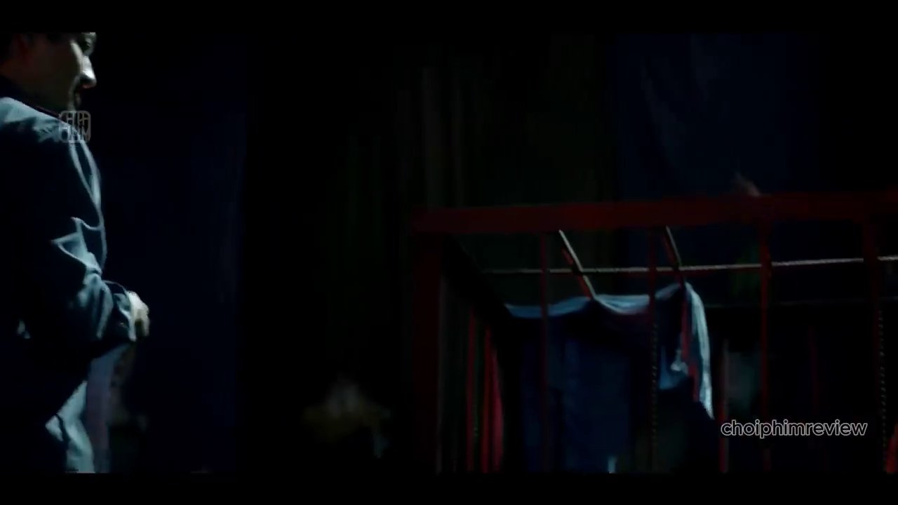 Cảnh Như nhìn qua khe hở, phát hiện ông Phúc đang đối diện với người đàn ông bị giam giữ trong căn phòng tối, ánh đèn le lói.