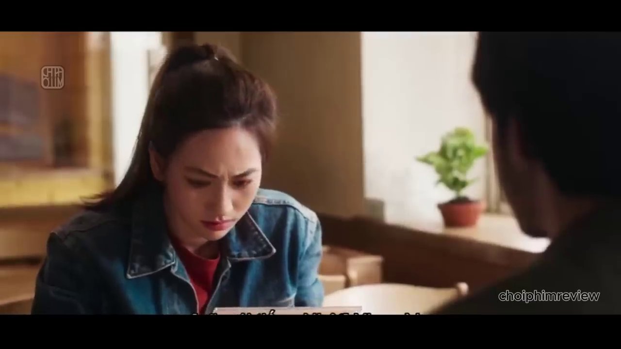 Nhật Hạ lặng lẽ ngắm nhìn những bức ảnh từ người cha gửi về - mối liên kết duy nhất của cô với ông trong suốt những năm tháng xa cách.