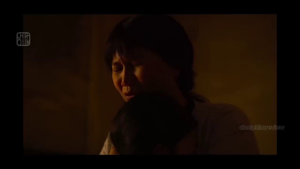 Khoảnh khắc Thành che chắn cho con gái, đôi mắt đầy sợ hãi và quyết tâm bảo vệ, phản chiếu lại ký ức bị bạo hành của chính cô.